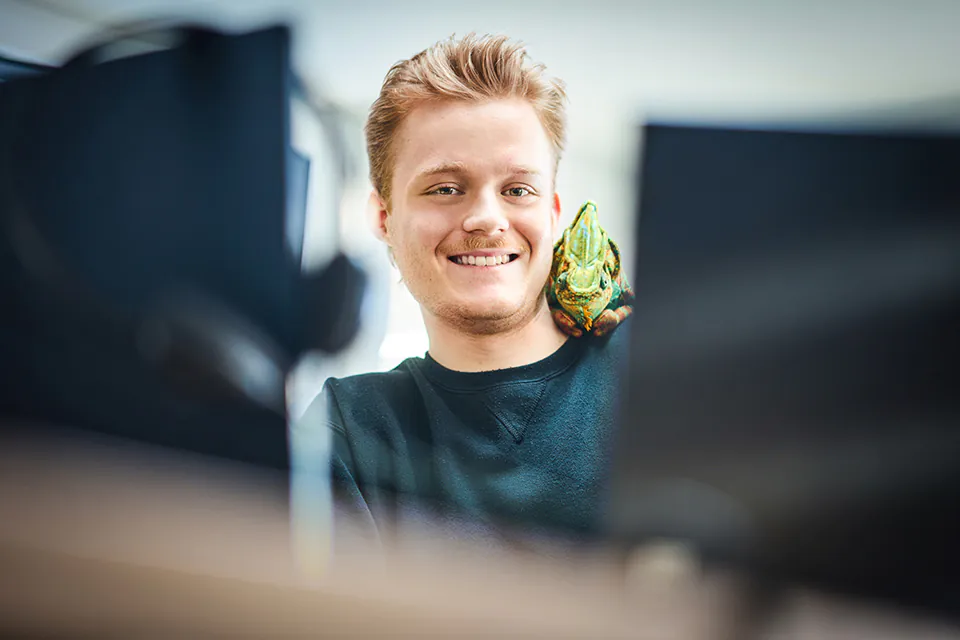 Moritz sitzt vor Laptop mit Chamäleon